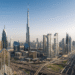 A panoramic view of Dubai’s modern skyline featuring a mix of high-rise residential and commercial towers under a bright blue sky.