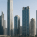 A panoramic view of Dubai's commercial business district with modern skyscrapers and well-developed infrastructure under clear skies.