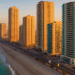 Aerial view of Ajman city skyline with modern buildings, coastal developments, and clear blue skies, showcasing the emirate’s growing real estate landscape in 2025.