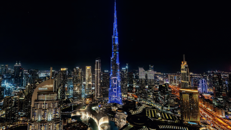 Dubai skyline at night featuring Burj Khalifa and Emaar buildings illuminated
