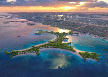 Aerial view of Naïa Island Dubai with luxury beachfront residences and Dubai skyline in the background during sunset