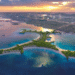 Aerial view of Naïa Island Dubai with luxury beachfront residences and Dubai skyline in the background during sunset