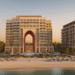 Aerial view of a beachfront development in Sharjah during sunrise, showing modern architecture and coastal landscape.