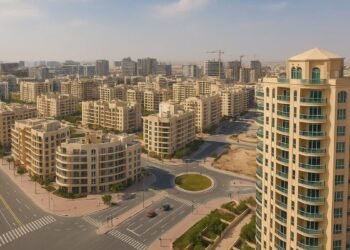 Jumeirah Village Circle (JVC) in Dubai with modern residential towers, villas, landscaped roads, and skyline in the background — real estate community view.