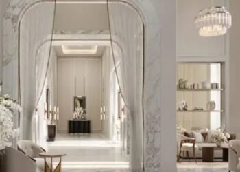 Elegant interior of Corinthia Dubai Residences featuring marble arches, soft lighting, modern furniture, and a serene luxury ambiance.