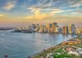 A wide-angle editorial photograph of Sharjah’s skyline featuring mid-rise residential buildings and active urban communities, reflecting the emirate’s expanding housing market.