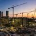 Construction cranes over an emerging UAE real estate development at dusk, reflecting the developer shift toward recurring income assets in 2026