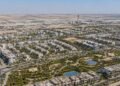 Aerial view of Dubai South master development showing residential communities and Al Maktoum International Airport in the background, representing Dubai South property investment 2026.
