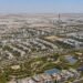 Aerial view of Dubai South master development showing residential communities and Al Maktoum International Airport in the background, representing Dubai South property investment 2026.