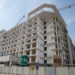Azizi Beach Oasis II low-rise blocks under construction in Dubai Studio City, October 2026, with façade work still under way. Commission or request a current site photo from Azizi; avoid launch renders, which show a finished building the story says is not yet close.